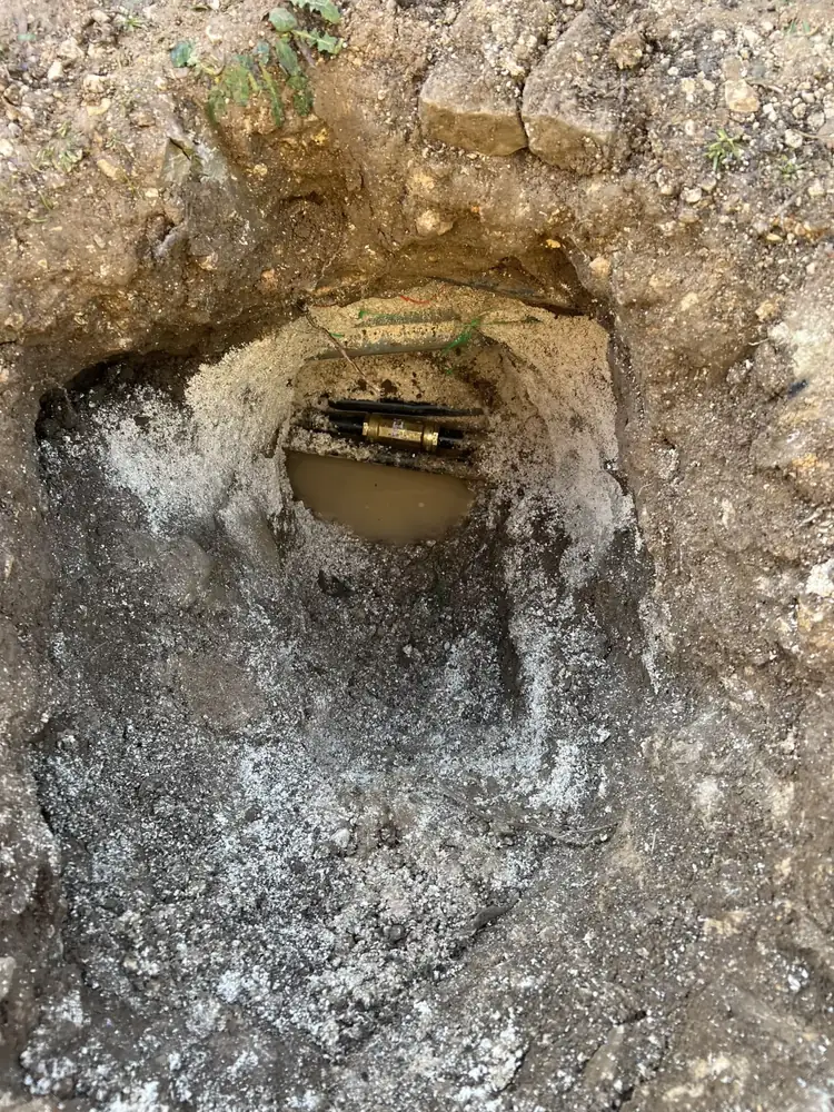 Canalisation enterrée dégagée pour réparation après recherche de fuite